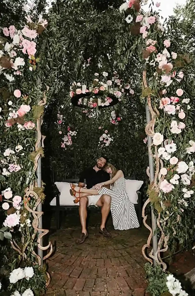Taylor Swift und Travis Kelce in der floralen Kulisse ihrer veröffentlichten Verlobungsfotos